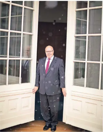  ??  ?? Minister mit Ausblick: Peter Altmaier schaut aus seinem Büro in den Regen.