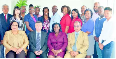  ?? PHOTO BY CHRISTOPHE­R THOMAS ?? Chinese ambassador to Jamaica, Tian Qi (second left, seated), with principal of the Montego Bay Community College, Dr Maureen Nelson (third left, seated), and members of her academic staff pose in a corner for The Gleaner’s photograph­er away from the displayed official photograph of Ruel Reid.