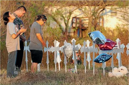  ?? PHOTOS: REUTERS ?? Miranda Hernandez, left, prays at sunset with father Kenneth and mother Irene at a row of crosses near the site of the shooting at the First Baptist Church of Sutherland, Texas.