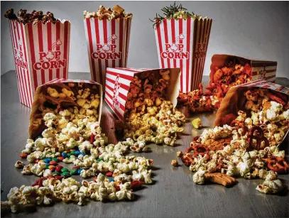  ?? CHRIS HUNT FOR THE ATLANTA JOURNAL-CONSTITUTI­ON/ STYLING BY SUSAN PUCKETT ?? It’s easy to re-create movie theater-style popcorn at home. Among the variations are (back row, from left) Salted Chocolate Popcorn, Hurricane Popcorn and Curry Lime Popcorn; (on their sides, from left) Movie Night Popcorn, Curry Lime Popcorn, Frito Pie Popcorn and Hurricane Popcorn.