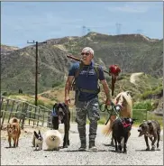  ?? MEL MELCON / LOS ANGELES TIMES ?? Dog trainer César Millán goes for a walk on his ranch in Santa Clarita, Calif., with a variety of dogs, a miniature horse, a goat and a macaw. All the animals and bird belong to Millán except for the great dane, which was visiting.