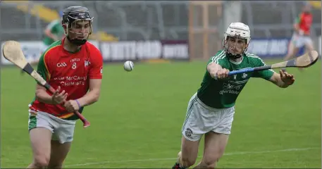  ??  ?? Ryan Mahon of Rapparees about to strike as Pádraig Doyle (Naomh Eanna) looks on.