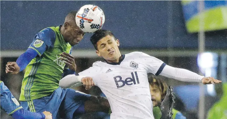  ?? — THE ASSOCIATED PRESS ?? Seattle Sounders defender Kelvin Leerdam heads the ball away from Vancouver Whitecaps forward Fredy Montero in the first half on Thursday in Seattle.