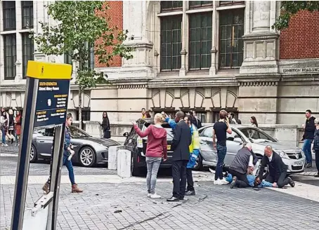  ?? — AFP ?? Chaotic scene: Policemen restrainin­g the suspect outside the Natural History Museum in London after the incident.