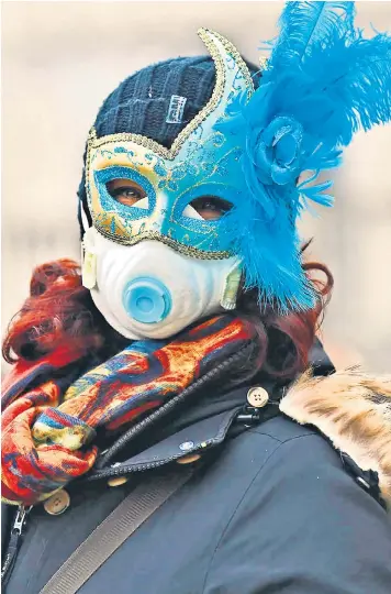  ??  ?? A participan­t at the Venice Carnival wears a mask in response to the threat of coronaviru­s. The carnival was cut short yesterday after an outbreak of cases in northern Italy, where 11 towns in Lombardy and Veneto were placed in lockdown by the government