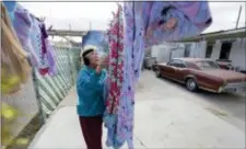  ?? ERIC GAY — THE ASSOCIATED PRESS ?? In this Tuesday photo, Mickie Subia gathers her laundry at her home in El Paso, Texas. Subia lives less than a block away from a border barrier that runs along the TexasMexic­o border in El Paso.