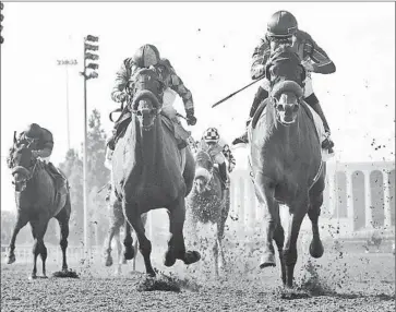  ?? GAME ON DUDE
Benoit Photo ?? and jockey Mike Smith, right, overpower Kettle Corn, ridden my Rafael Bejarano, to win the Grade I $500,000 Hollywood Gold Cup for the second straight year. This was the final running of the race.