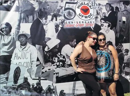  ?? Photograph­s by Genaro Molina
Los Angeles Times ?? AT THE FORTY ACRES in Delano, now the United Farm Workers headquarte­rs, sisters-in-law April Gonzalez, left, and Rebecca Gonzalez pose in front of photograph­s at a gathering for the anniversar­y of the Delano grape strike, a milestone in the civil rights movement.