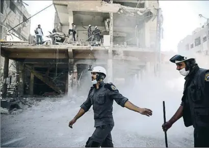  ?? SAMEER AL-DOUMY / AFP ?? Cascos blancos actuando tras un bombardeo en el 2016 en una zona rebelde cerca de Damasco