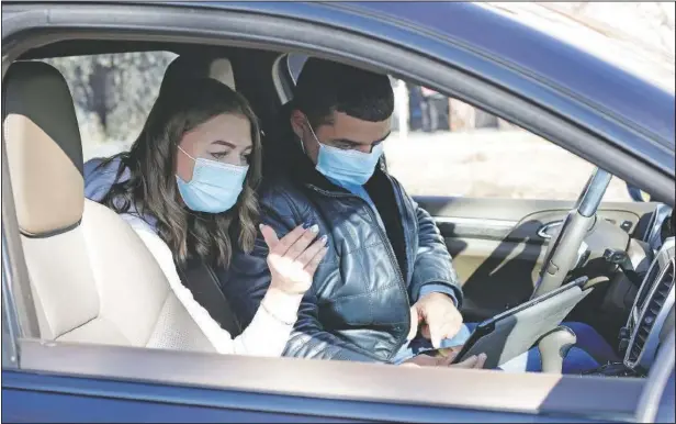  ?? (AP/Alexander Novikov) ?? Vadim Kostenko looks at a map with Dr. Veronica Arzhadeyev­a in Irkutsk, Russia, prior to driving her to visit a patient.