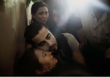  ??  ?? Below: In Latakia Province, Syria, a couple mourn the loss of their son, who was the first soldier from their small village of 125 people to be killed in the Syrian civil war in 2013.