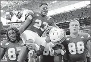  ?? AP/LYNNE SLADKY ?? Miami tight end Christophe­r Herndon IV (23) is carried off the field by teammates Saturday after the No. 3 Hurricanes defeated Virginia 44-28 in Miami. The Hurricanes extended their winning streak to 15 games and secured their first season with at...