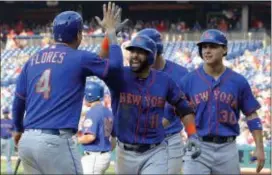  ?? THE ASSOCIATED PRESS ?? Mets’ Jose Bautista, center, high-fives Wilmer Flores after Bautista hit a grand slam during the fifth inning of Thursday’s game against the Phillies in Philadelph­ia.