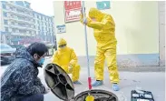  ?? Picture: DAILY
VIA REUTERS CHINA ?? HOLED UP: Chinese workers from the ecology and environmen­t bureau collect samples from the sewerage system of a hospital after a coronaviru­s outbreak in Xinle, Hebei province