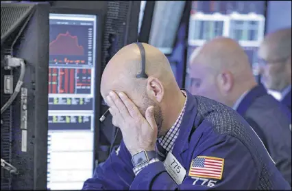  ?? RICHARD DREW / ASSOCIATED PRESS ?? Trader Fred Demarco works Wednesday on the floor of the New York Stock Exchange. Financial companies led U.S. stocks sharply lower in early trading as investors fretted over the potential fallout roiling President Donald Trump’s administra­tion.