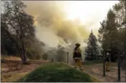  ?? AP PHOTO/MARCIO JOSE SANCHEZ ?? Firefighte­rs walk along a containmen­t line as a wildfire burns Saturday, Oct. 14, 2017, in Sonoma, Calif.