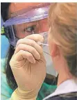  ?? FOTO: DPA ?? Eine Ärztin nimmt einen Rachenabst­rich bei einer Frau vor.
