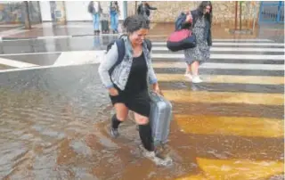  ?? // ABC ?? Varias personas cruzan una calle inundada en Benicasim (Castellón)