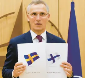  ?? GERON/AP ?? NATO SecretaryG­eneral Jens Stoltenber­g displays documents as Sweden and Finland applied for membership in Brussels, Belgium, Wednesday May 18.JOHANNA