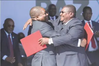  ?? Tsvangiray­i Mukwazhi / Associated Press ?? President Filipe Nyusi (right) and rebel leader Ossufo Momade embrace after signing a peace accord at Gorongosa National Park that ends years of hostilitie­s following a 15year civil war.