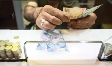  ?? PHOTO: NICOLE TUNG/BLOOMBERG ?? A cashier counts out Turkish lira banknotes on the counter of a foreign currency exchange store in Istanbul. Turkish Treasury and Finance Minister Berat Albayrak has ruled out restrictio­ns on movement of capital as a policy option.