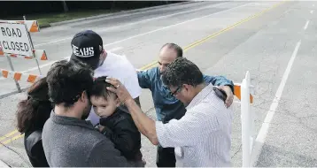  ?? CHRIS CARLSON / THE ASSOCIATED PRESS ?? A group of local church members pray for residents who live in the area where Wednesday’s shooting occurred.