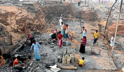  ?? AP ?? Rohingya refugees stand at the site of the fire at a refugee camp in Balukhali, southern Bangladesh.