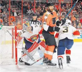  ?? BRUCE BENNETT/GETTY IMAGES ?? Backup goalie James Reimer of the Panthers attempts to look around Philadelph­ia’s Sean Couturier, seeking to lock in on the puck.