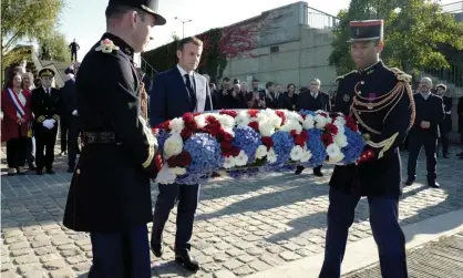  ?? Photograph: Rafael Yaghobzade­h/AFP/Getty Images ?? Emmanuel Macron lays a wreath of flowers near the Pont de Bezons near Paris.