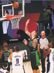  ?? Pool / Getty Images ?? Daniel Theis (27) of the Boston Celtics scores against the Orlando Magic during overtime of a NBA game at AdventHeal­th Arena at the ESPN Wide World Of Sports Complex on Sunday in Lake Buena Vista, Fla. The Celtics won 122-199 in overtime.