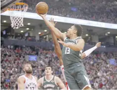  ?? — USA TODAY Sports photo ?? Milwaukee Bucks guard Malcolm Brogdon (right) goes up to make a basket against the Toronto Raptors at Scotiabank Arena. Milwaukee defeated Toronto.