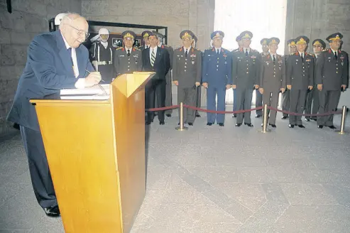  ??  ?? Prime Minister Necmettin Erbakan signs a memorial book at mauseloum of Atatürk, founder of Republic, as top military brass look on in this undated photo. Karadayı, seen here in second left in the front row of soldiers, was sentenced to life on Friday...