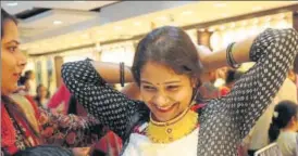  ?? SUBHANKAR CHAKRABORT­Y/ HT PHOTO ?? A woman tries on a gold necklace at a jewellery store in Lucknow on the occasion of Dhanteras, on Tuesday.