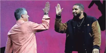  ?? JUSTIN SULLIVAN, GETTY IMAGES ?? Apple senior vice president of Internet Software and Services Eddy Cue, left, high-fives recording artist Drake during the Apple Music introducti­on Monday.