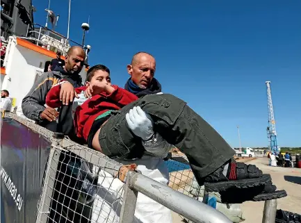  ?? PHOTO: REUTERS ?? A crew member of the Malta-based Migrant Offshore Aid Station ship Phoenix carries a disabled child off the ship after it arrived with migrants and bodies on board, in Augusta on the island of Sicily, Italy.