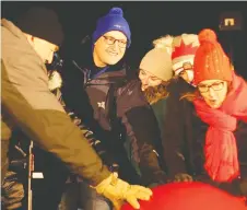  ??  ?? Mayor Drew Dilkens and his family push the giant red button to turn on the lights of the giant Christmas tree at the centre of the display.