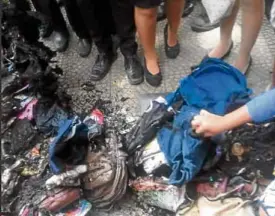  ?? —EARL VINCENT CAÑAVERAL ?? CHARRED REMAINS Students sift through what remained of their bags to recover clothes, cell phones or laptops after a Bicol Central Academy school official ordered them burned, as seen in another photo showing the bags in flames, as punishment for students who did not comply with the no-bag policy on Friday in Libmanan, Camarines Sur province.