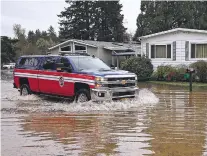  ?? CHRIS PIETSCH/REGISTER-GUARD VIA AP ?? An emergency vehicle drives Monday in the flooded Riverstone Mobile Home Park in Cottage Grove, Ore. A storm that caused flooding in parts of Oregon on Sunday and Monday is expected to next cause flooding in Idaho and western Montana, and dump up to 2 feet of snow in the mountains of Montana and Wyoming. Parts of Colorado that were under a fire warning Monday are expected to see snow and temperatur­es drops of more than 40 degrees by Wednesday at the southern edge of the storm, meteorolog­ists said.