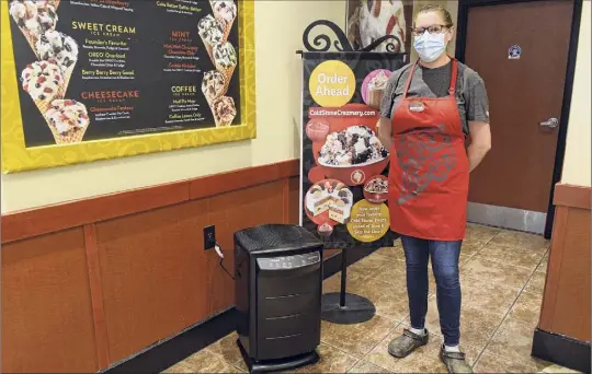  ?? Photos by Lori Van Buren / Times Union ?? General Manager Amanda Martin poses with a new disinfecti­ng filtration system in Cold Stone Creamery at Stuyvesant Plaza. Bountiful Bread and other local restaurant­s also recently installed the air filtration system, which disinfects the air in addition to filtering it.