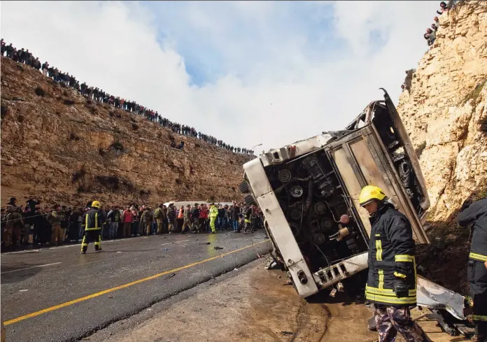  ?? ?? Reddingswe­rkers inspectere­n op 16 februari 2012 de plek van de botsing tussen de vrachtwage­n en de schoolbus met de Palestijns­e kinderen.