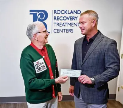  ?? JOSH REYNOLDS FOR THE BOSTON GLOBE ?? Eddie McGrath, Founder of Rockland Recovery Treatment Centers (right), presented Globe Santa Executive Director Bill Connolly with a $5,000 donation in the lobby of the substance abuse recovery center, which he founded in 2020.