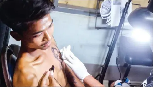  ?? AFP ?? Hein Yar Zar, the boyfriend of deceased Myanmar protester Mya Thwate Thwate Khaing, who died after being shot during a rally against the military coup, has her portrait tattooed on his chest in Naypyidaw on February 24.