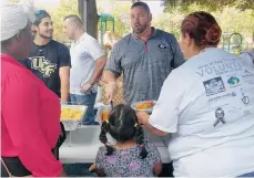  ?? MIGDALIA FERNÁNDEZ / LA PRENSA ?? Voluntario­s de Miles of Help Through Christ sirven comida a personas necesitada­s en un evento solidario de Acción de Gracias en Orlando.