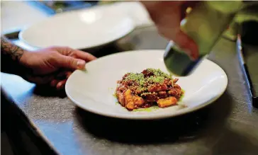  ?? [PHOTO BY BRYAN TERRY, THE OKLAHOMAN] ?? Chef Jonathan Krell works on a dish in the kitchen at Patrono in Oklahoma City.