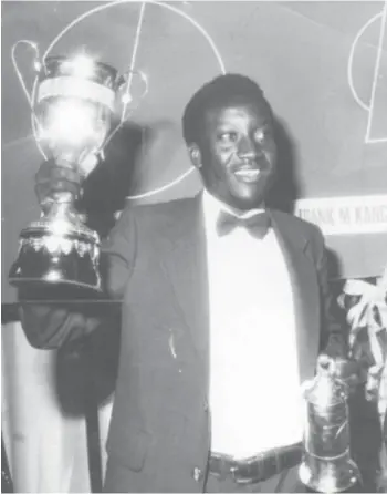  ??  ?? NUMERO UNO . . .Dynamos legend, David “Yogi’’ Mandigora, lifts the Soccer Star of the Year trophy, after being crowned the best footballer on the domestic scene, in 1980