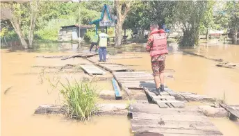  ??  ?? Police and Bomba personnel checking the flood situation in Long Teru yesterday.