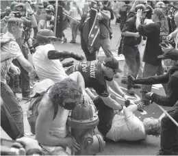  ?? MATT EICH/THE NEW YORK TIMES ?? A civil trial against dozens of organizers of the 2017 “Unite the Right” rally in Charlottes­ville, Virginia, begins Monday. Above, people scuffle at the rally.