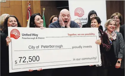  ?? TAYLOR CLYSDALE PETERBOROU­GH THIS WEEK ?? Staff at the City of Peterborou­gh donate $72,500 raised through bake sales, silent auctions, ugly sweater days and more to the annual United Way Peterborou­gh and District campaign, with CEO Jim Russell, centre, reacting to the cheque.