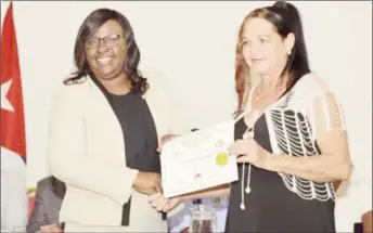  ?? (GINA photo) ?? Dr. Karen Cummings (left), Minister within the Ministry of Public Health awards a certificat­e to Medical Laboratory Technician, Dr Ada Josefa Valides Perez