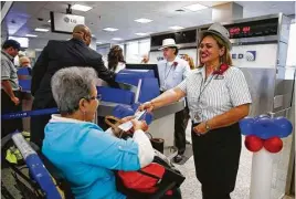  ??  ?? United Airlines gate agent Arlene Pena checks in passengers for the historic flight on Saturday. A United official believes Houston likely got a direct-to-Cuba flight because the city is a gateway to Latin America.